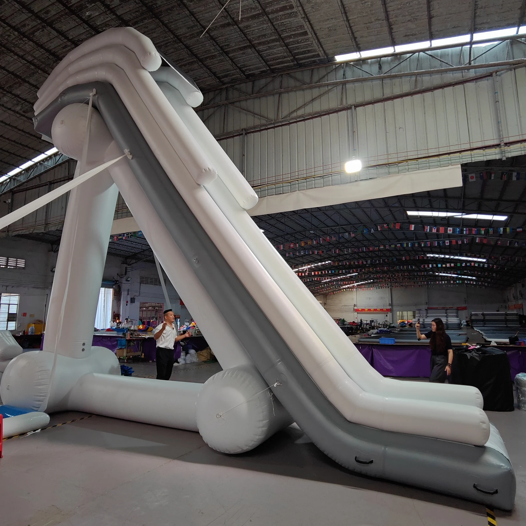 White-and-grey inflatable water slide with elevated landing and rear supports